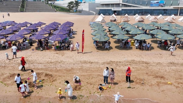 Tourists escape the summer heat under umbrellas at Liandao beach in Lianyungang, Jiangsu Province