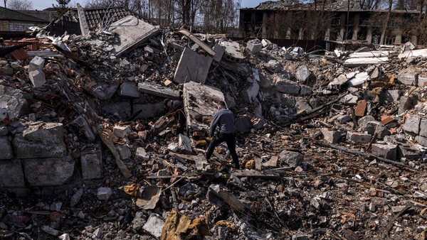Police walk among the rubble in Bohdanivka village, where crime is alleged to have happened