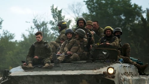 Ukrainian soldiers ride on an armored personnel carrier in the eastern Luhansk region of Ukraine today