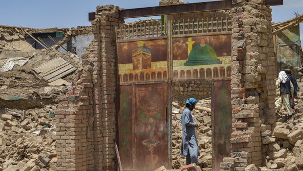 An Afghan man stands besides a door of a house damaged by an earthquake in Bermal district, Paktika province