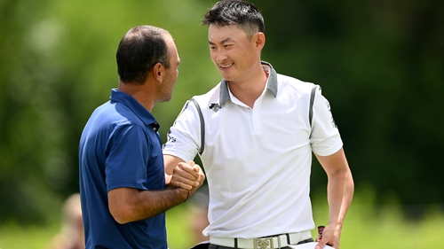 Li Haotong shakes hands with Hugo Leon of Chile at the18th hole