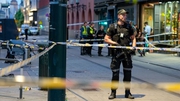 A Norwegian police officer stands guard in the streets of central Oslo between security tape lines