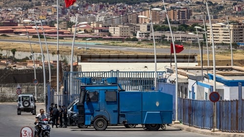 Moroccan security forces stand guard at the border fence separating Morocco from Spain's North African Melilla enclave