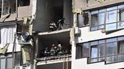Rescuers and firefighters work in a damaged residential building, hit by Russian missiles in Kyiv