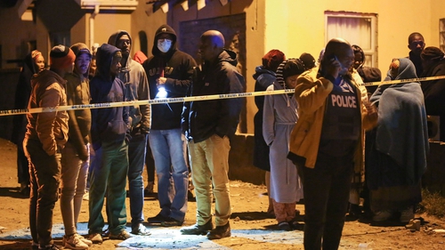 Families wait outside the tavern in East London, South Africa for news of their loved ones