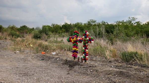 Colourful crosses mark the spot where the trailer truck in which 51 migrants was parked in San Antonio, Texas
