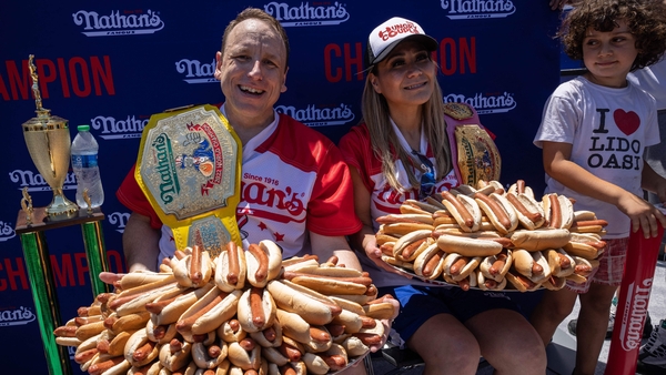 Joey Chestnut and Miki Sudo display trays with 63 and 40 hotdogs respectively