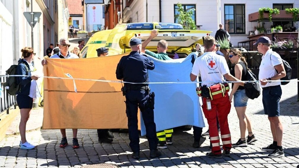 Police and rescue services transfer a woman who has been seriously injured in a stabbing at the Almedalen political festival into an ambulance