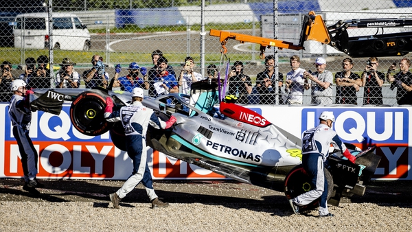 Lewis Hamilton's car is towed away after he crashed into barriers