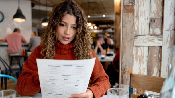 woman reading restaurant menu