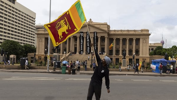 A demonstrator waves the national flag outside the president's office in Colombo, Sri Lanka