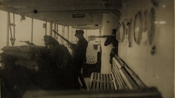 Soldiers on board the SS Lady Wicklow watching land for snipers as they approach Passage West, Cork in August 1922. Image courtesy of the National Library of Ireland