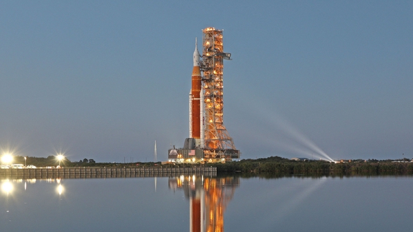 The massive Artemis I rocket is illuminated at dusk at the Kennedy Space Centre.