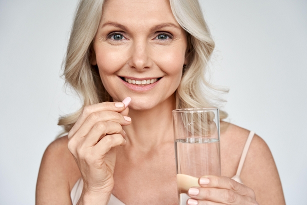 woman taking supplement tablet