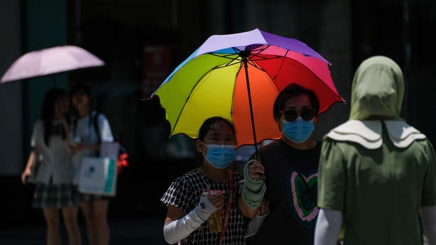 People shield themselves with umbrellas during a heatwave earlier this morning in Chongqing, China
