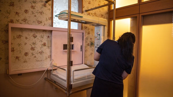 A staff member demonstrates the baby hatch room at Jikei hospital in Kumamoto