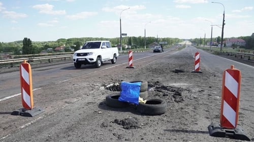 A picture taken on 21 July shows craters on Kherson's Antonovsky bridge across the Dnipro river caused by a rocket strike