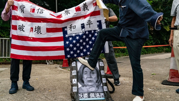 A pro-China supporter steps on a defaced photo of Nancy Pelosi during a protest against her visit to Taiwan outside the Consulate General of the US in Hong Kong