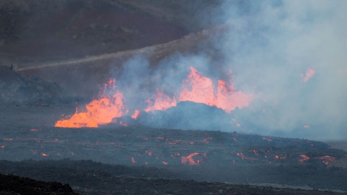 Lava can be seen spewing from a fissure in the ground