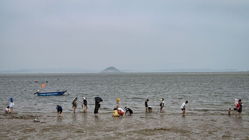People relaxing last week on a beach in Xiamen, where Taiwan's Jinmen Island can be seen at the back