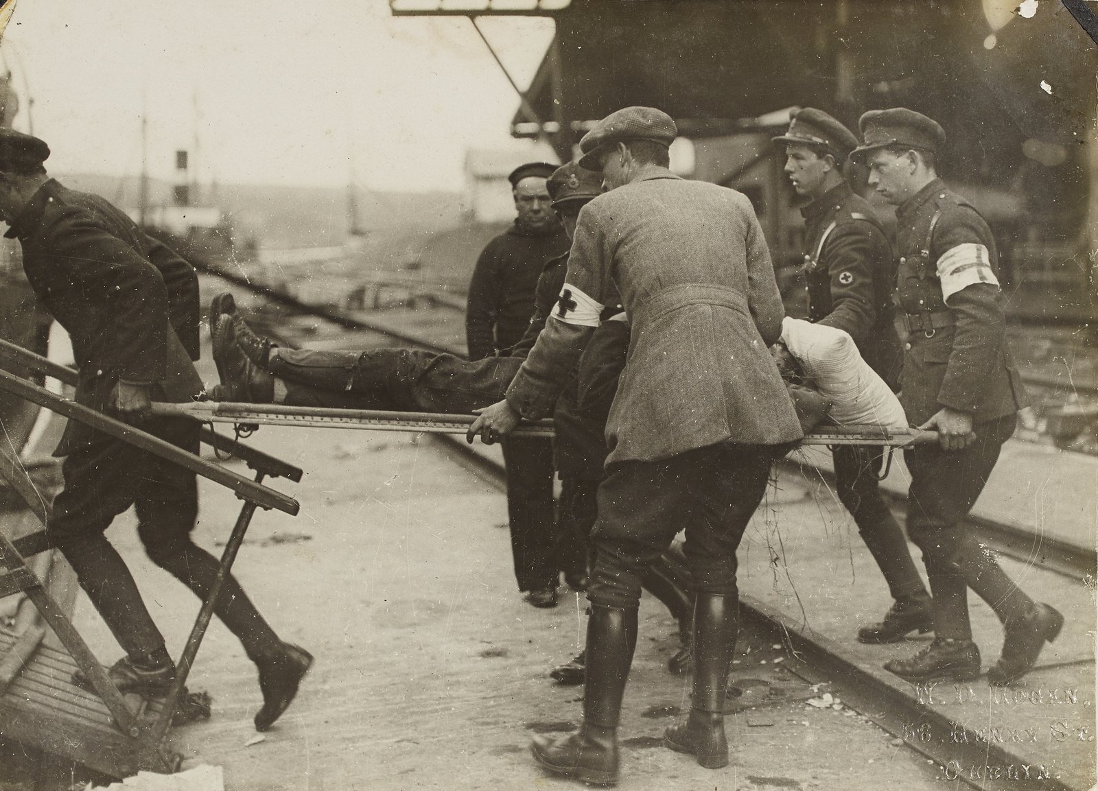 Image - Members of the National Army medical corps taking one of the wounded back to the Lady Wicklow which formed the base hospital until the troops had advanced from Passage West to Cork City. Image courtesy of the National Library of Ireland