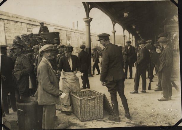 A woman handing out sandwiches to National Army troops on their arrival in Cork. Image courtesy of the National Library of Ireland