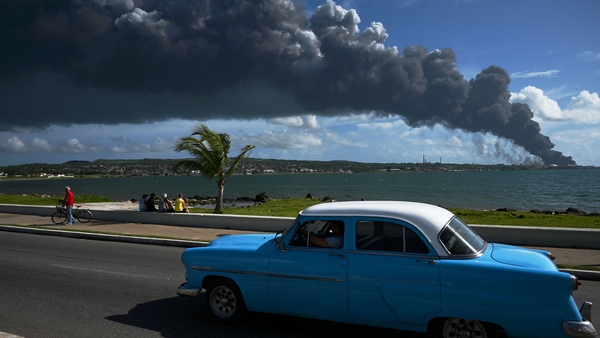 Black smoke from an oil tank on fire is seen rising across the water