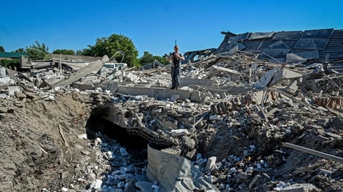 An official examines the ruins of a furniture factory following a missile strike on the city of Kharkiv
