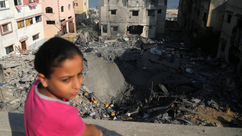A Palestinian girl inspects damage outside a residential building in Gaza City today