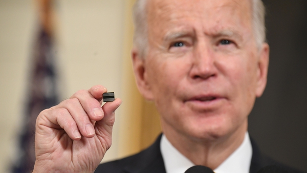 US President Joe Biden holds a microchip, calling today's measure