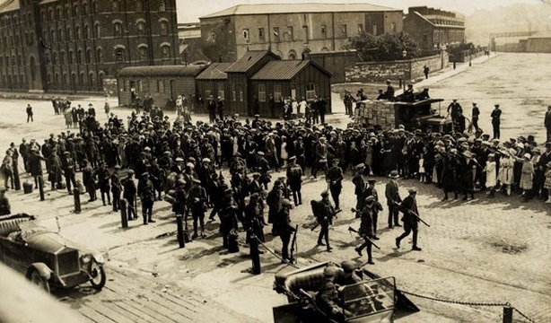 Civil War scene on the quays in Cork; a group of men in civilian attire surrounded by armed and uniformed soldiers while "admirers" look on. Photo: National Library of Ireland, 1922