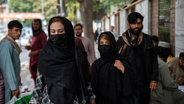 Women cover their faces when walking down a street in Kabul, Afghanistan, yesterday