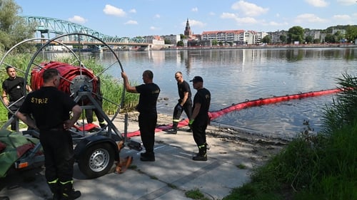 Polish firefighters set up a floating dam to catch dead fish from the river Oder, near Szczecin, Poland