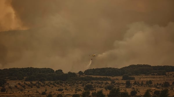 A firefighting helicopter works to extinguish a fire in Bejis