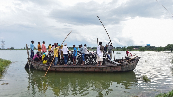 Villagers use a boat to cross a waterlogged road in a village near Allahabad, India