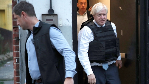 Boris Johnson (R) taking part in a raid by Metropolitan Police officers in London