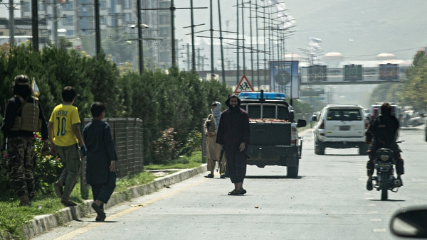Taliban fighters stand guard along a road near the Russian embassy after a suicide attack in Kabul