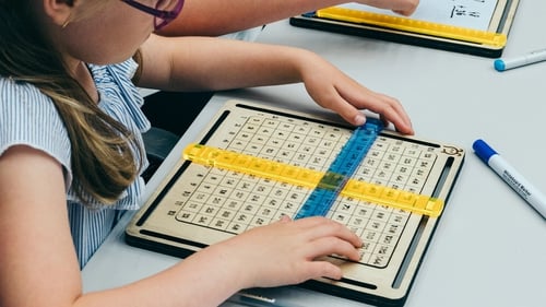 The device consists of a grid, sliders and a whiteboard that allow interactive maths learning