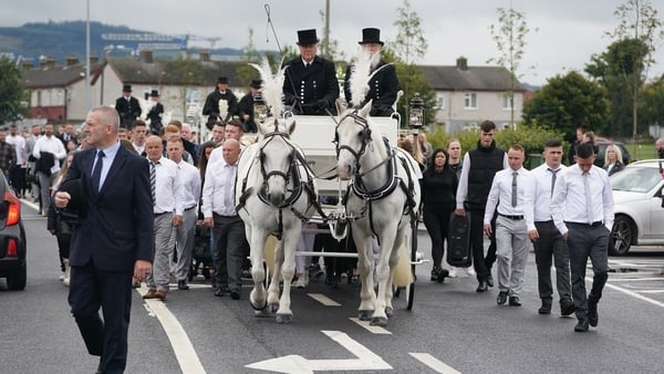 Horse-drawn carriages carry the coffins to Bohernabreena Cemetery after the funeral mass
