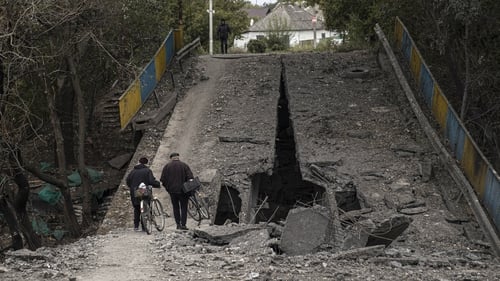 People inspect a collapsed bridge after Ukrainian army liberated the town of Balakliya in Kharkiv region