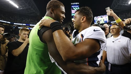 DK Metcalf (L) of the Seattle Seahawks embraces his former team-mate Russell Wilson