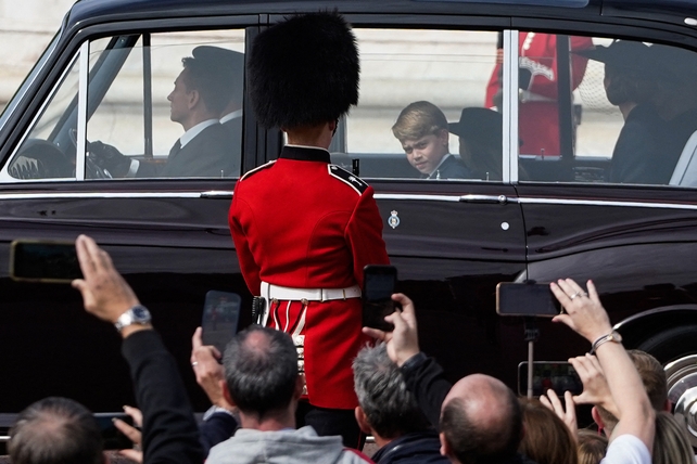 Members of the royal family travel past crowds lining the streets, many taking pictures (Niklas Halle'n/AFP)