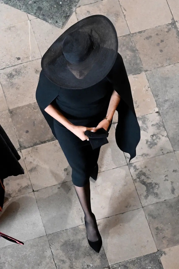 The Duchess of Sussex in a black dress with caped detailing (Gareth Cattermole/PA)