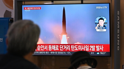 People in Seoul watch file footage of a North Korean missile test