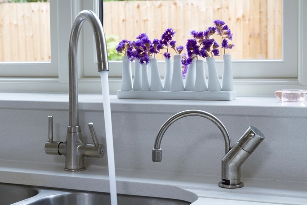 Running tap with plants in background (Alamy/PA)