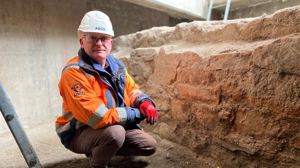 Archaeologist Niall Brady next to the exposed 18th century sea wall in Dublin Port.