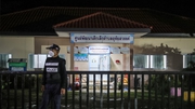 A police officer stands guard outside a child care centre in Nong Bua Lamphu, Thailand