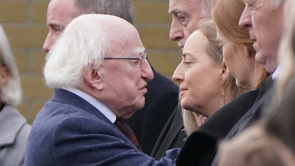 President Higgins hugs Tracey O'Flaherty, wife of James O'Flaherty, following this morning's funeral