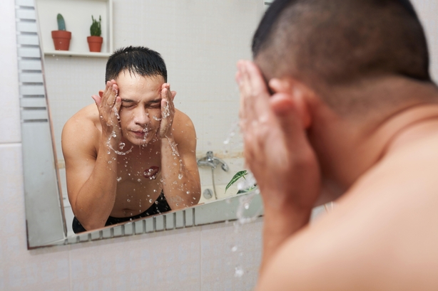 man washing face