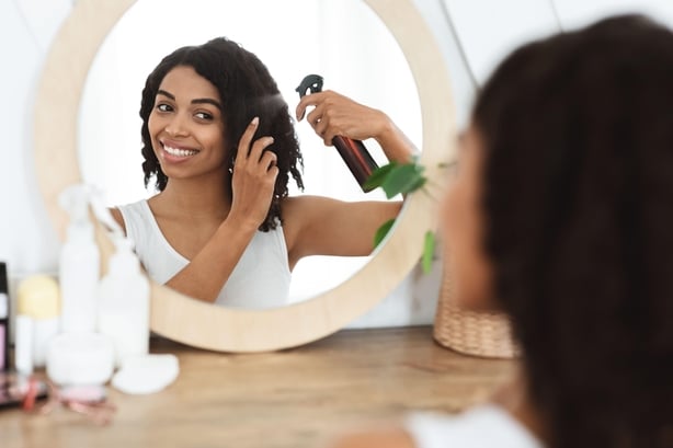 woman applying heat protection spray
